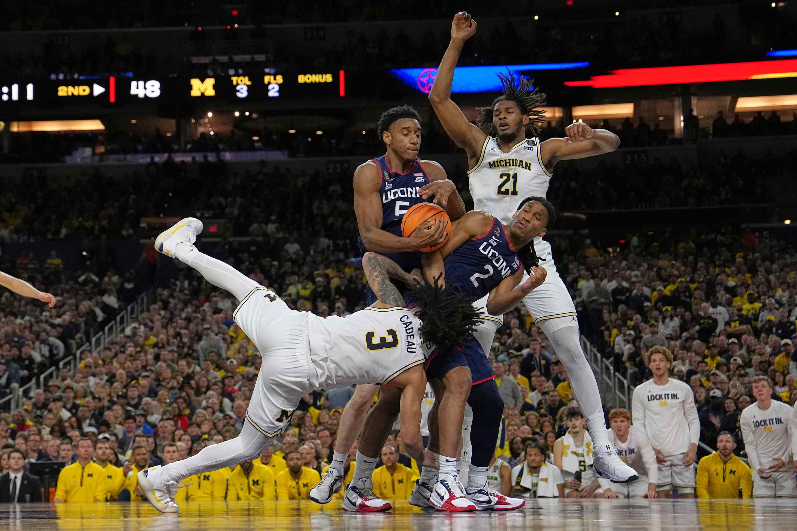 College basketball star Tarris Reed shielding the ball from opponents.